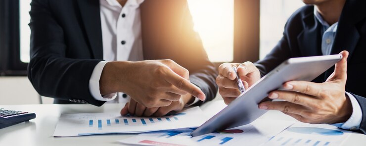 Rechts- und Geschäftsberater, zwei Geschäftsleute, die sich unterhalten, planen, Investitionen und Marketing auf Tablet im Büro analysieren.