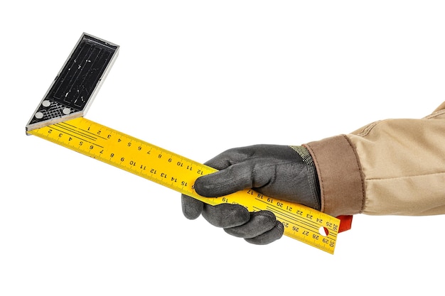 Rechtwinkliges Lineal aus gelbem Metall in der Hand des Arbeiters in schwarzem Schutzhandschuh isoliert auf weiß