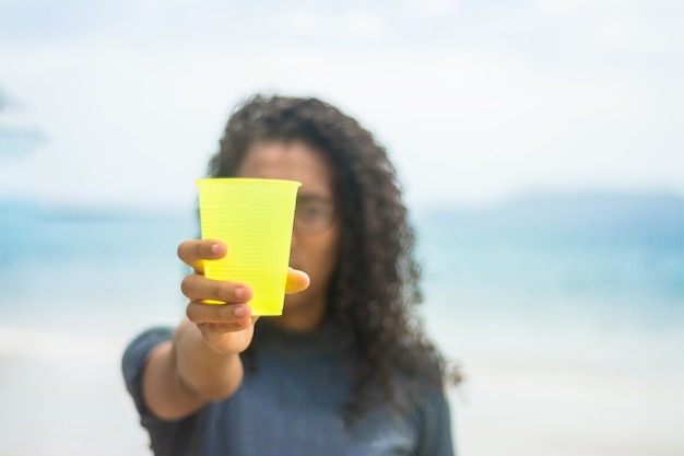 Recicla, recogiendo vasos de plástico en la playa