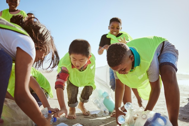 Reciclagem de praia e grupo de crianças limpando o ambiente para caridade voluntária ou ajuda de apoio a ONG e trabalho em equipe Diversidade amigos ou estudantes reciclando plástico para poluição ou dia da terra