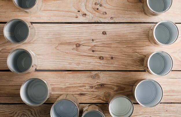 reciclaje creativo en casa latas de aluminio y recipiente de plástico reciclado con tierra en madera de jardín