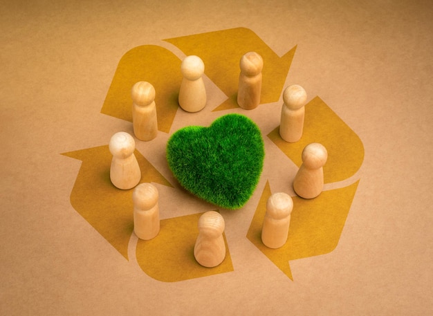 Reciclar revitalizando a cooperação de grupos de voluntários, a comunidade, a eco-sustentabilidade, os conceitos de responsabilidade ambiental, o coração verde cercado por figuras de pessoas de madeira no fundo do símbolo de reciclagem.