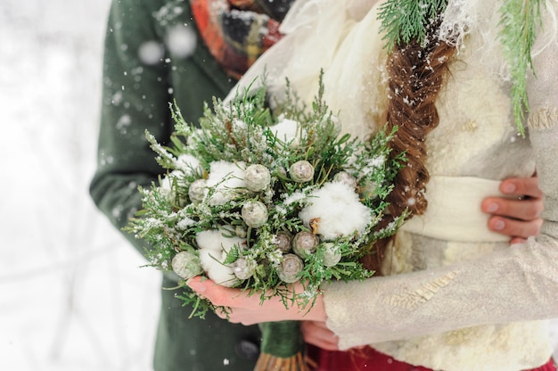 Los recién casados se abrazan en el bosque de invierno. Pareja enamorada. Ceremonia de boda de invierno.