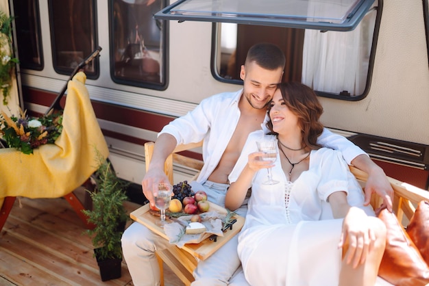 Los recién casados se abrazan tiernamente, se besan y se disfrutan mutuamente en un campamento de rv en un remolque Wedding Love