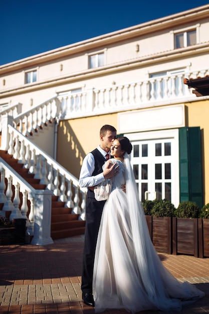 Recién casados se abrazan tiernamente, se besan y disfrutan el uno del otro Paseo de los amantes Increíble pareja de novios sonriente