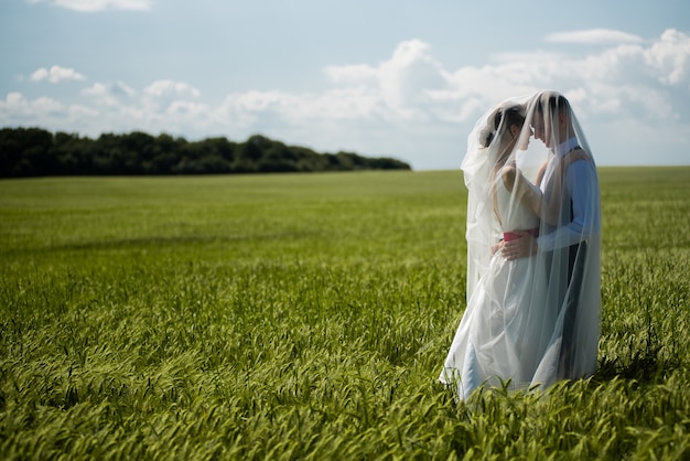 Los recién casados se abrazan tiernamente el día de la boda.