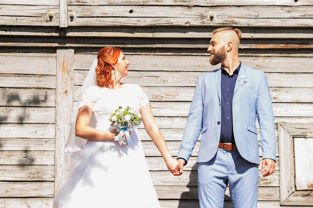 Recién casados amantes de la pareja hipster en traje de novia y traje en el parque