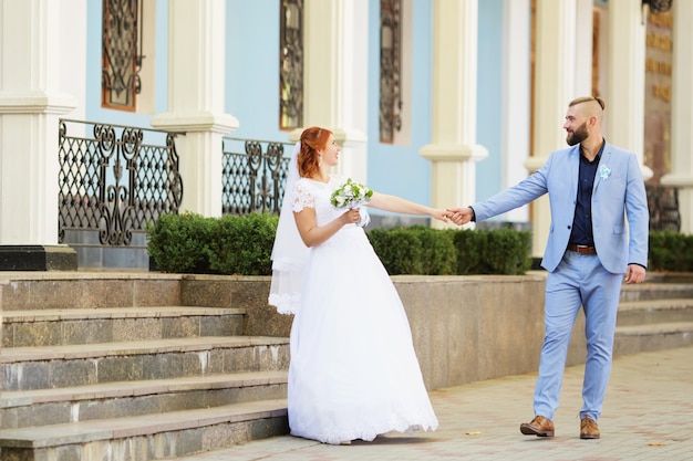 Recién casados amantes de la pareja hipster en traje de novia y traje en el parque