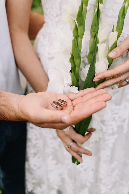 Recién casados con anillos de boda en las manos