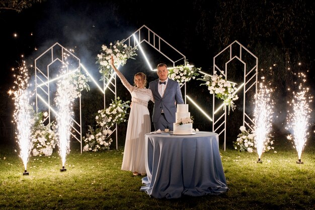 Recién casados felizmente cortan, ríen y prueban el pastel de bodas