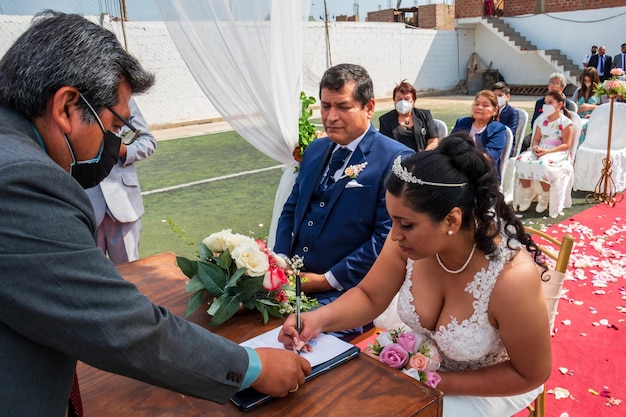 Recién casados firmando el acta de matrimonio Pareja de 40 y 50 años