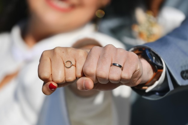 Los recién casados muestran anillos de boda a la cámara.