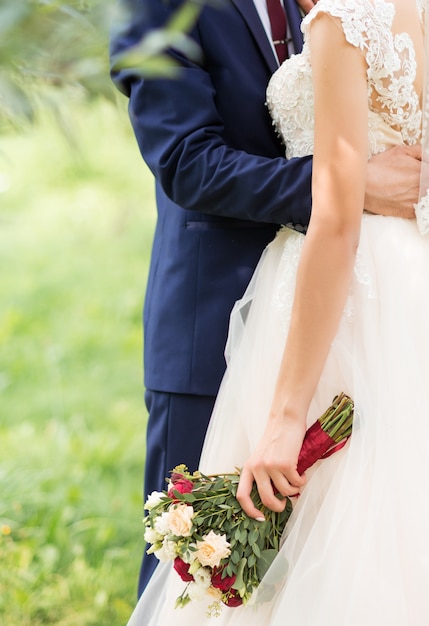 Recién casados en el parque besándose