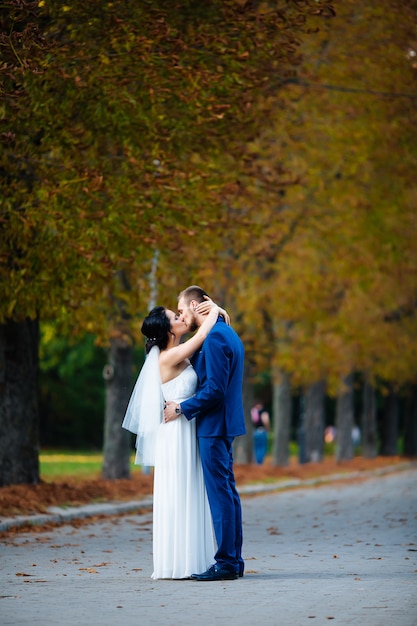 Recién casados posando en un parque