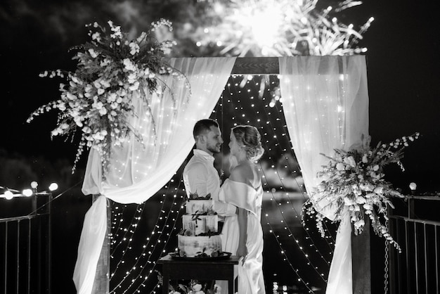 Foto los recién casados se ríen felizmente y prueban el pastel de bodas