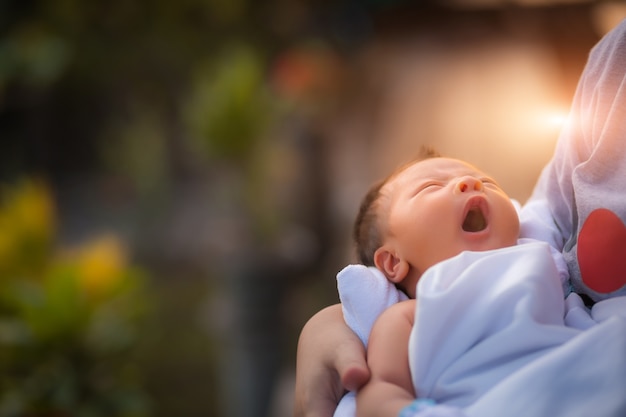 Foto recién nacido bebé descansando en brazos de las madres.