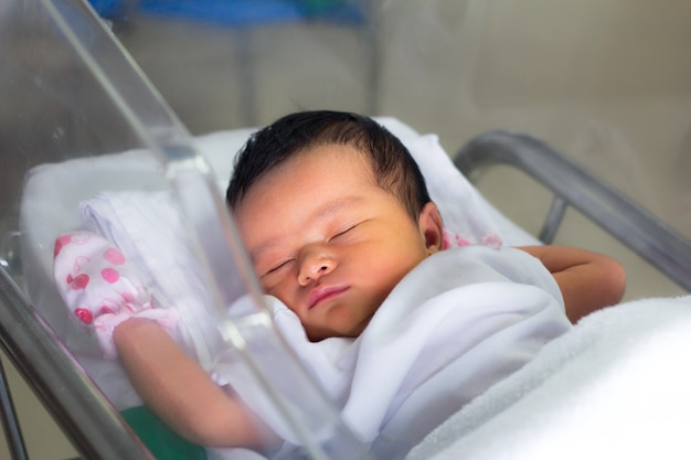 Foto recién nacido dormido en la manta en la sala de partos