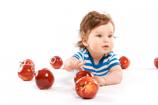 Un recién nacido rodeado de manzanas.