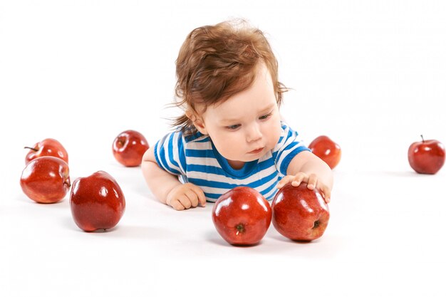 Un recién nacido rodeado de manzanas.