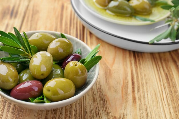 Recipiente con aceitunas enlatadas sobre fondo de madera