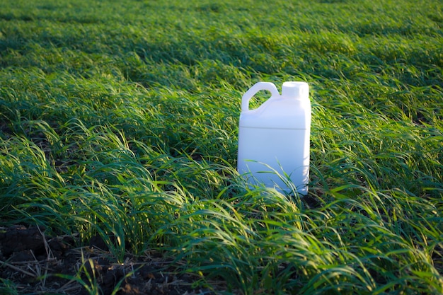 Recipiente blanco contra el fondo de recipientes de productos químicos agrícolas