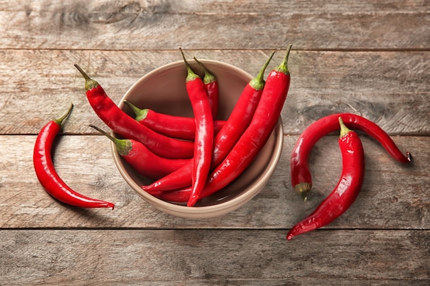 Recipiente con chiles frescos en la mesa de madera