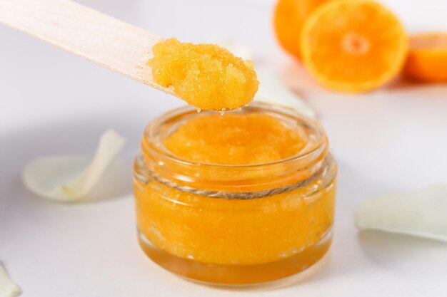 Recipiente com esfoliante de açúcar e laranjas para tratamentos de spa