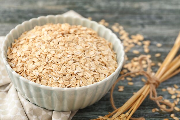 Recipiente con copos de avena sobre fondo de madera