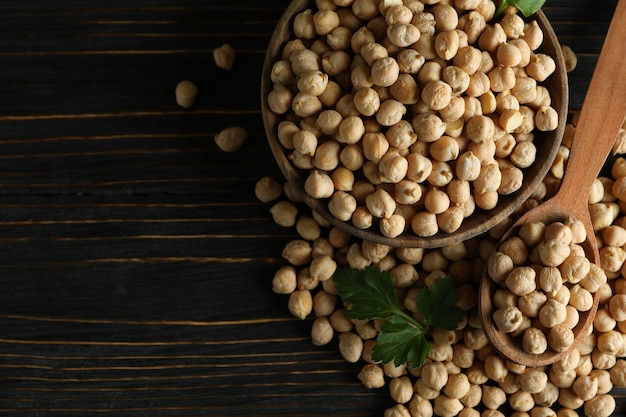 Recipiente y cuchara con garbanzos sobre mesa de madera