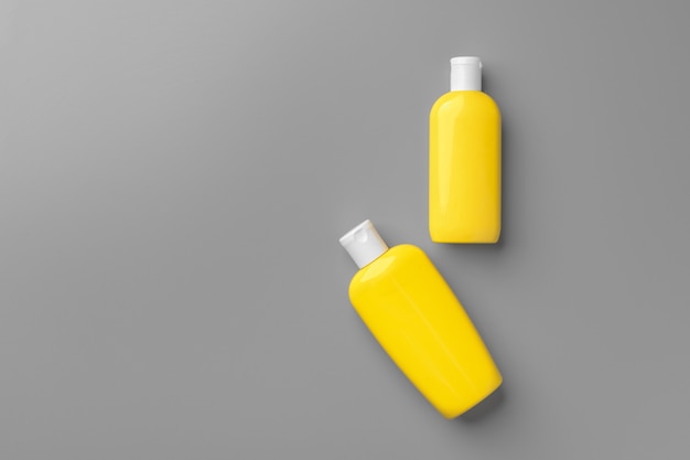 Recipiente de cosmético amarelo em fundo cinza