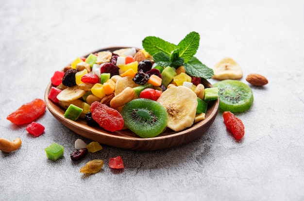 Recipiente con diversos frutos secos y nueces sobre un escritorio de hormigón gris