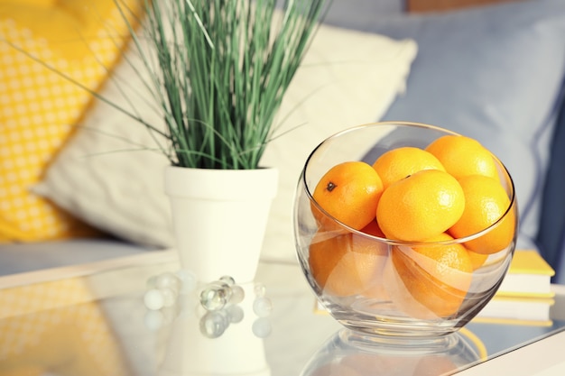 Recipiente con mandarinas frescas en la mesa de la sala de estar, cerrar