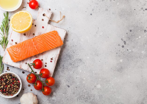 Recipiente plástico com fatia de salmão fresco com óleo de tomate e limão