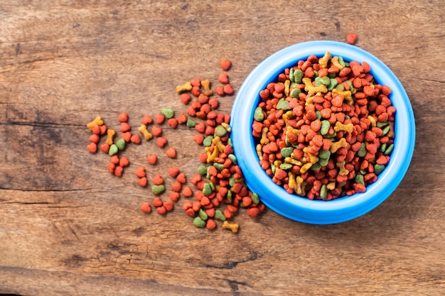 Recipiente de plástico lleno con alimento seco para perros aislado sobre fondo blanco Vista superior de alimentos para mascotas de grano con copia