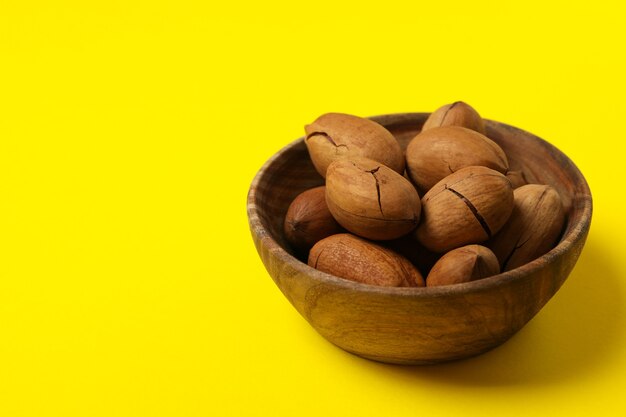 Recipiente con sabrosas nueces pecanas en amarillo