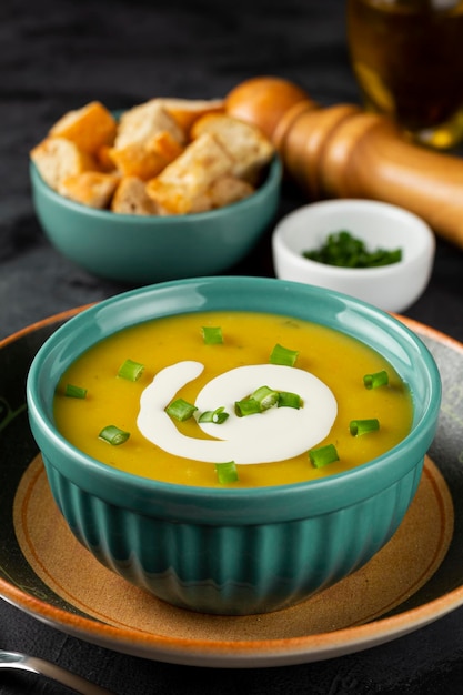 Recipiente con sopa de calabaza sobre la mesa.