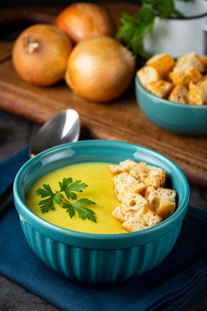 Recipiente con sopa de cebolla y picatostes sobre la mesa.