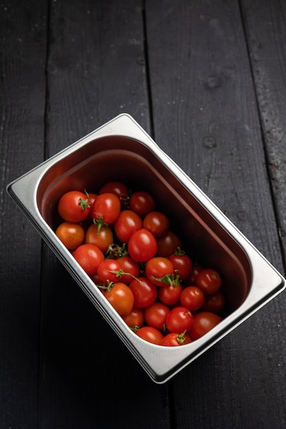 Un recipiente de tomates con el tallo.