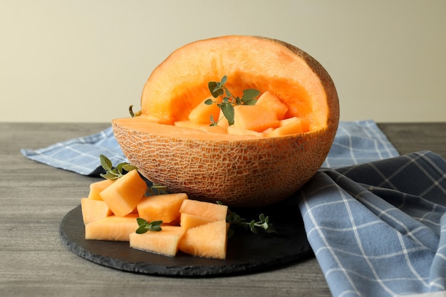 Recipiente con trozos de melón en mesa con textura gris