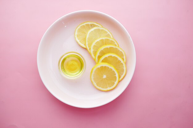 Recipiente de vidrio de aceite y limón en la mesa