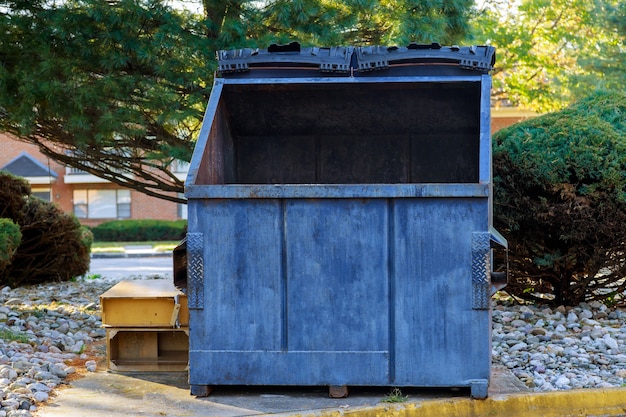 Recipientes de lixo de latas perto de edifícios residenciais em ecologia, poluição ambiental.