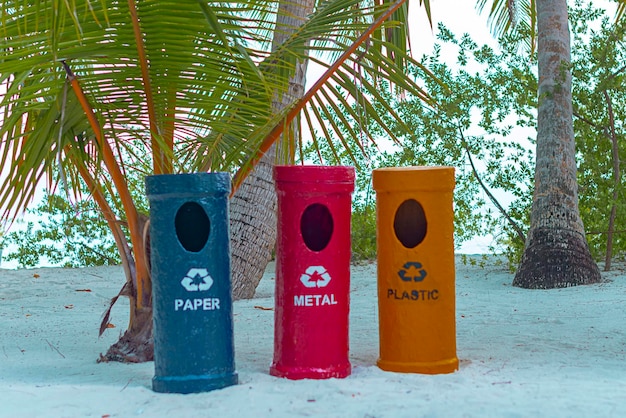 Recipientes de lixo metálico para coleta separada de lixo em uma ilha tropical o conceito de ecologia e problemas de poluição do oceano mundial
