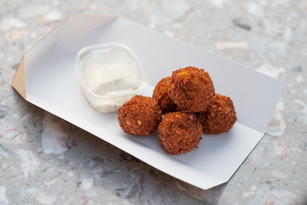 Recipientes de papel de comida para llevar de falafel a domicilio con bolas de falafel y salsa