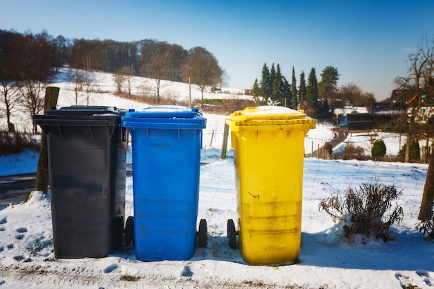 Recipientes de reciclaje. Paisaje invernal con cubos de basura coloridos secos en Alemania. Protección del medio ambiente
