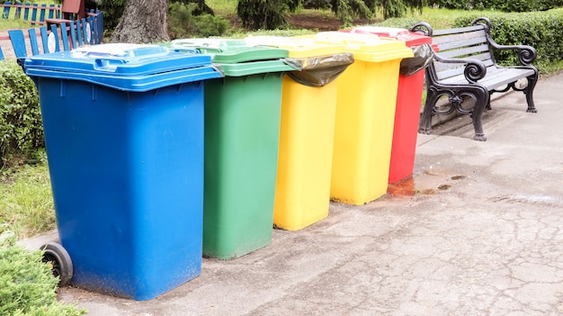 Foto recipientes separados para coleta de lixo no parque. latas de lixo multicoloridas na rua. recipientes coleta seletiva de resíduos. conceito de poluição ambiental.