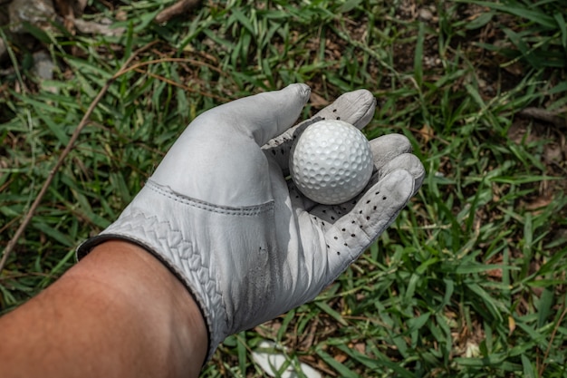 Recoge una pelota de golf sobre hierba