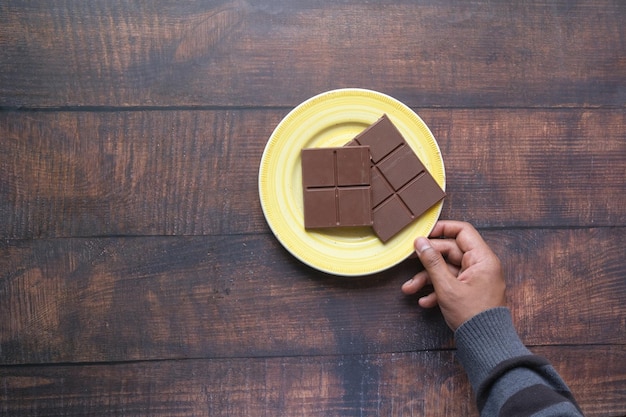 Recoger a mano chocolate negro en un plato