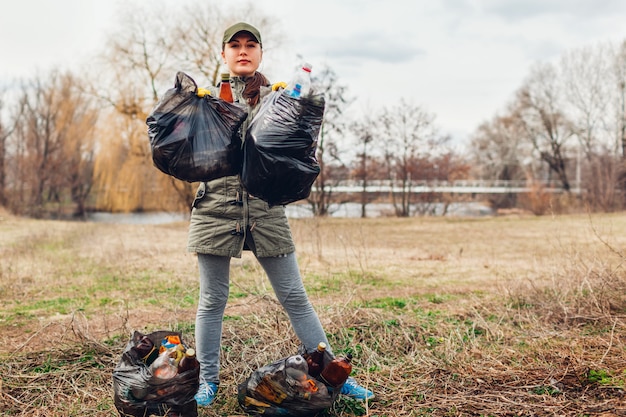 Foto recogida de basura. mujer voluntaria limpiando la basura en el parque. recoger basura al aire libre. ecologia y medio ambiente
