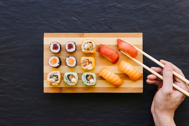 Foto recolección de sushi a mano del tablero