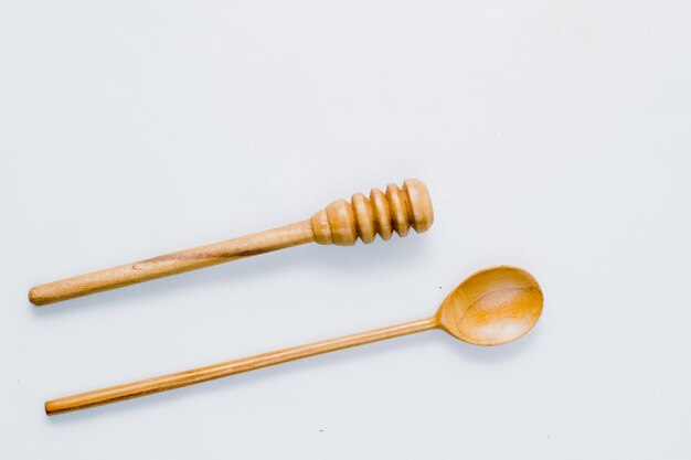 Recolector de miel y cuchara de madera sobre un fondo blanco Grado alimenticio